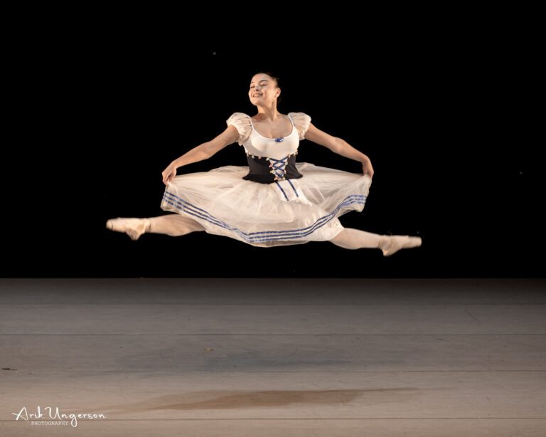 רקדנית בהופעת בלט על הבמה עם תאורה דרמטית רקדנית בהופעת בלט על הבמה עם תאורה דרמטית